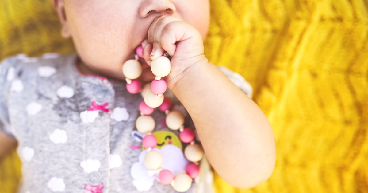 Baby nuckelt an Kette