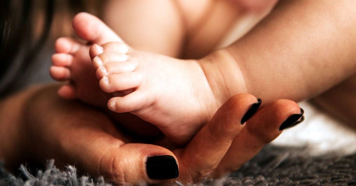 Mutter hält die Füße ihres Babys