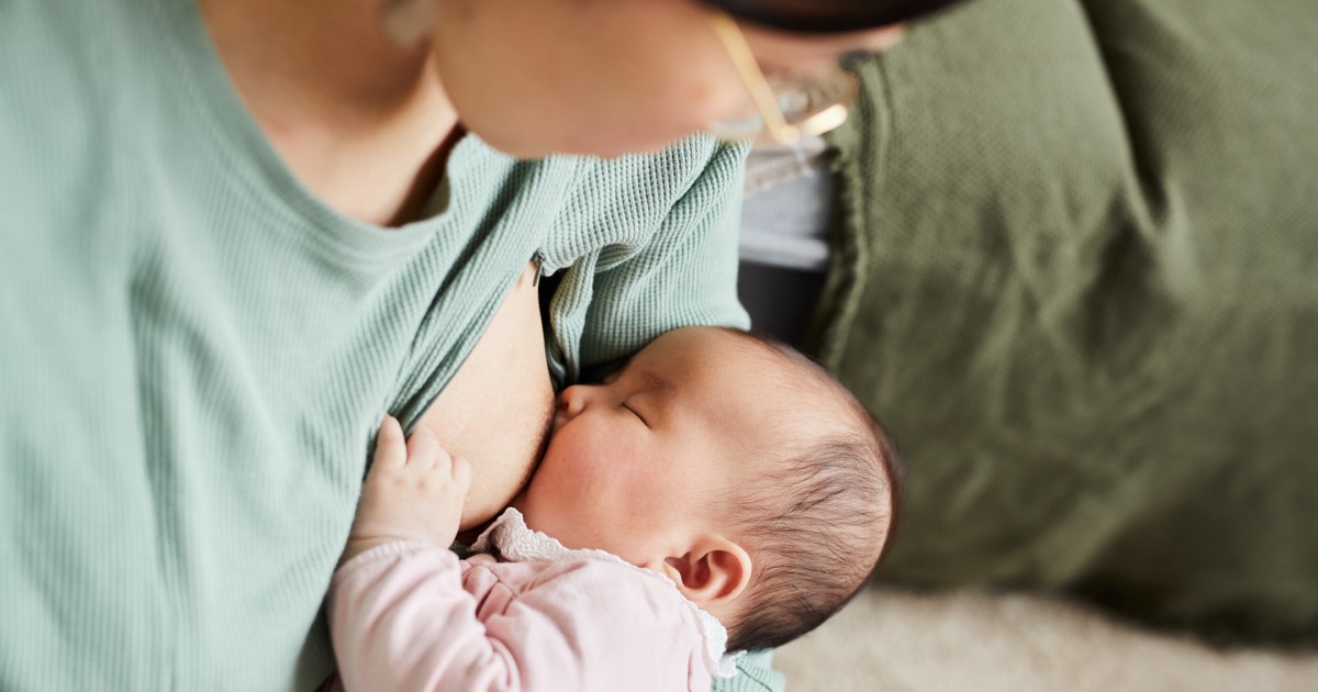 Junge Mutter und ihr Baby mit voller Milchflasche