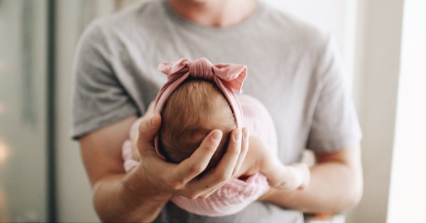 Vater hält Neugeborenes nach Geburt